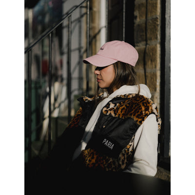Person wearing a pink cap and leopard print backpack with 'PARIA' branding.