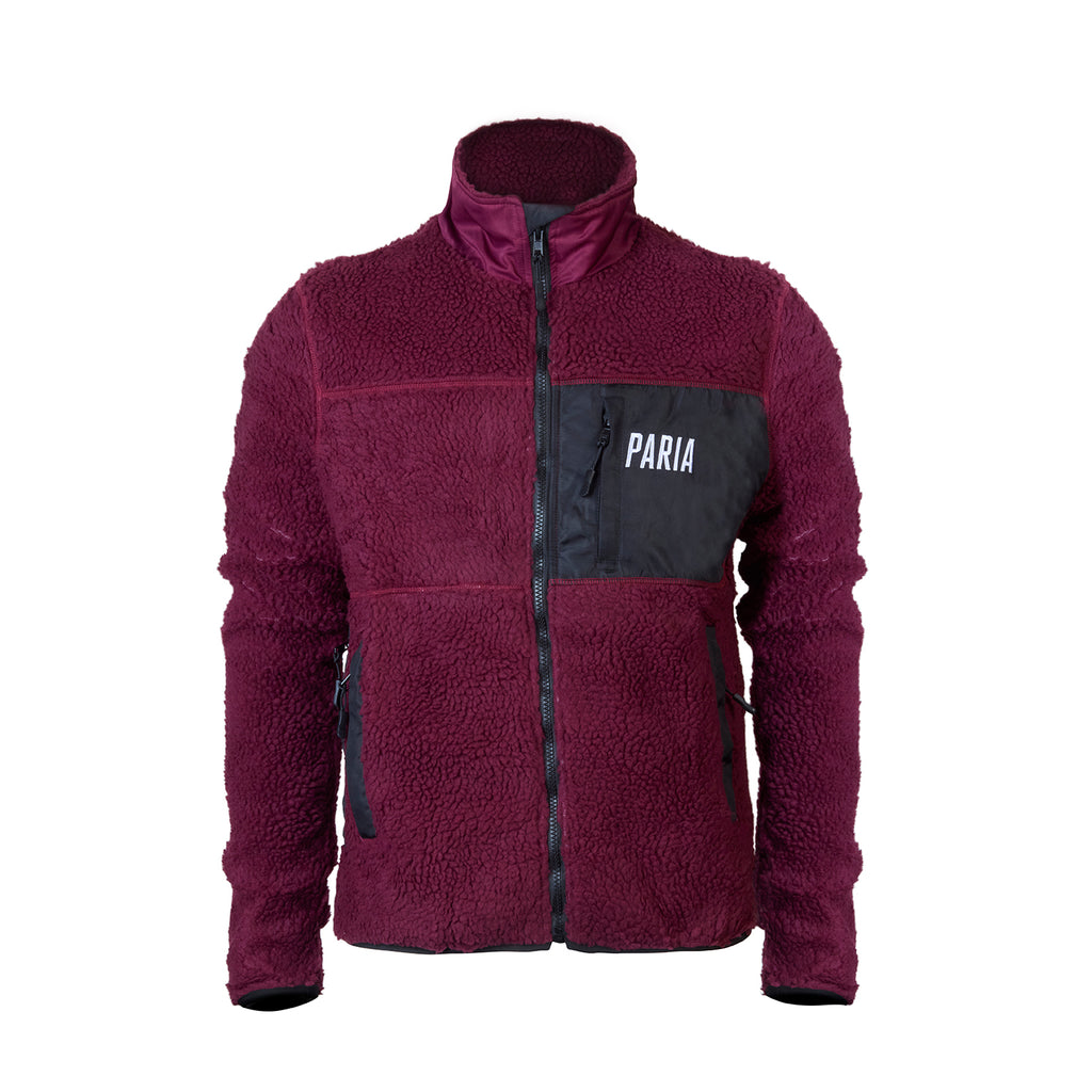 A purple fleece cycling jacket with zip pockets and contrast zips, featuring a collar and the brand name 'Paria' on the chest.