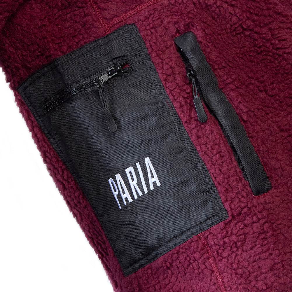 A purple fleece cycling jacket with zip pockets and contrast zips, featuring a collar and the brand name 'Paria' on the chest.