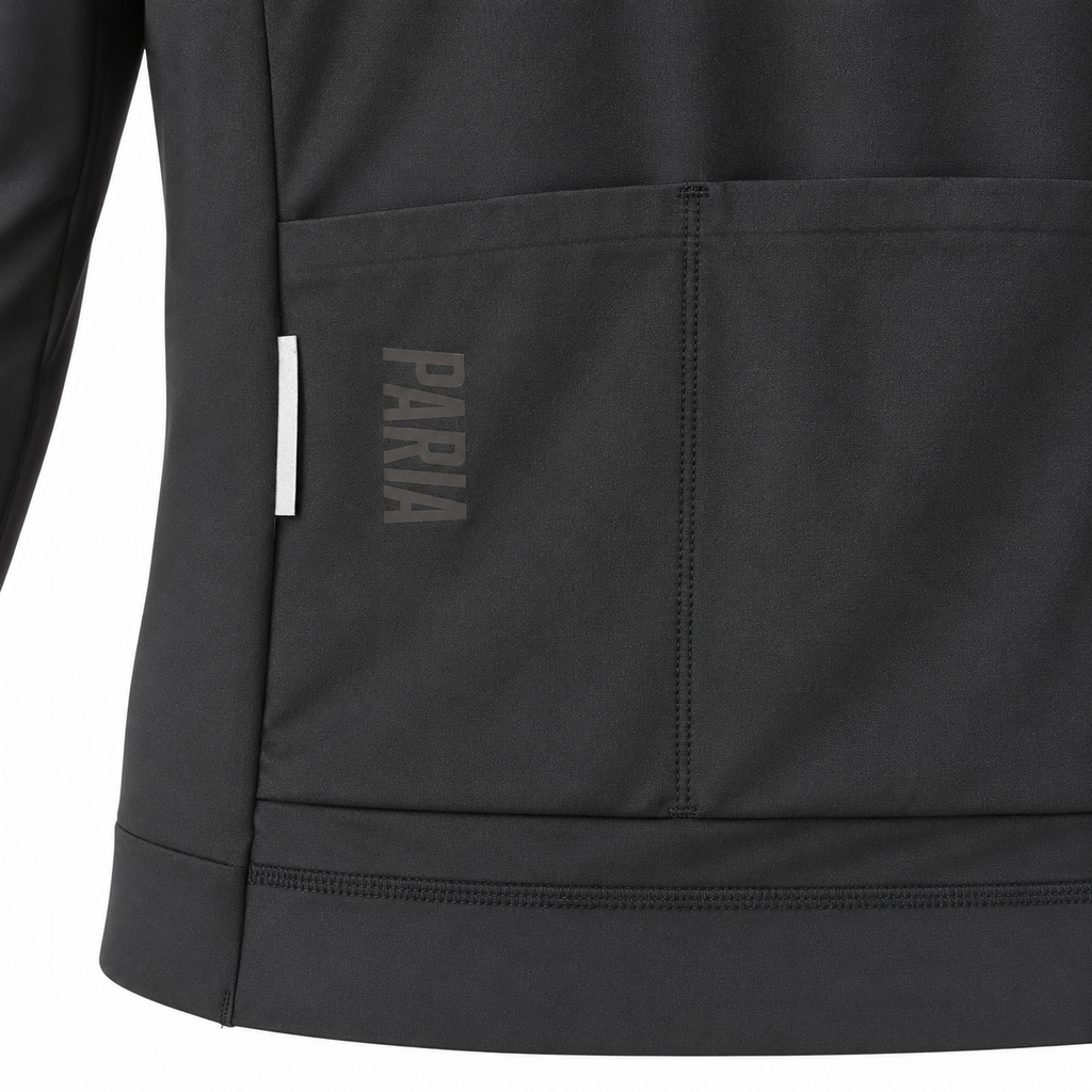 Close-up of a dark gray athletic jacket showing a front pocket with the brand name 'PARIA' printed vertically in gray on the pocket flap, alongside a small white side tag.