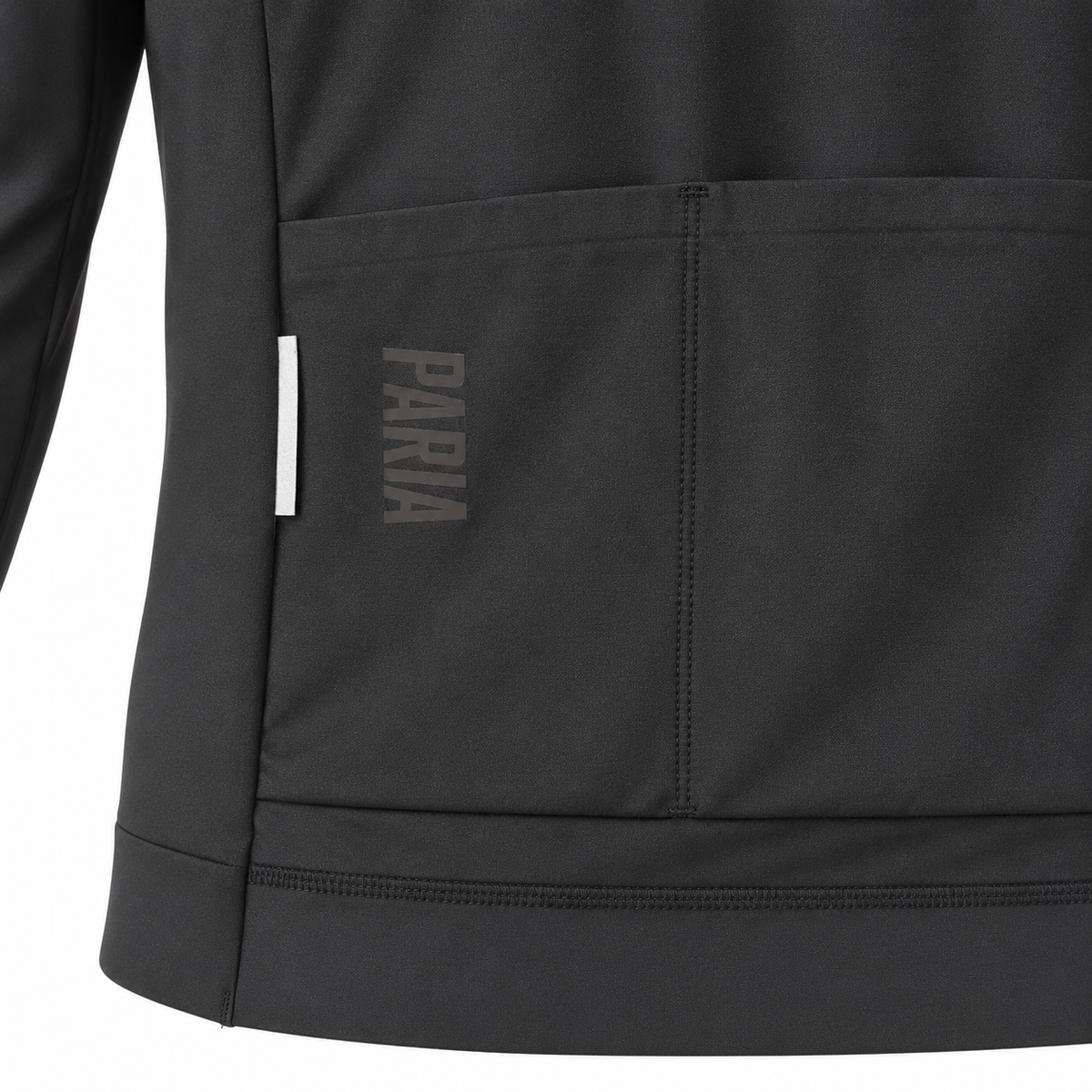Close-up of a dark gray athletic jacket showing a front pocket with the brand name 'PARIA' printed vertically in gray on the pocket flap, alongside a small white side tag.