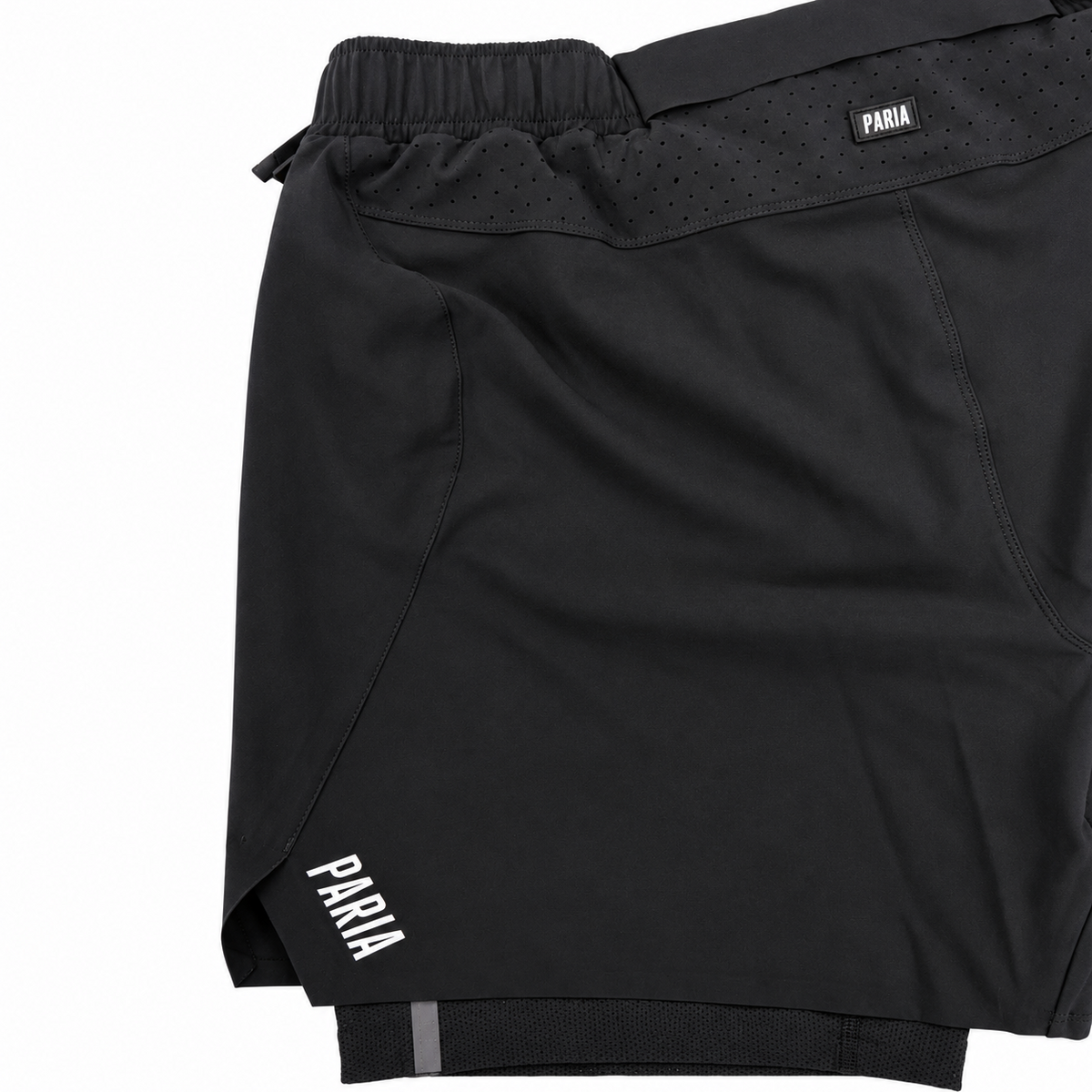 Black athletic shorts with a white 'PARIA' logo on the waistband and a small logo patch near the hem, shown on a plain white background.