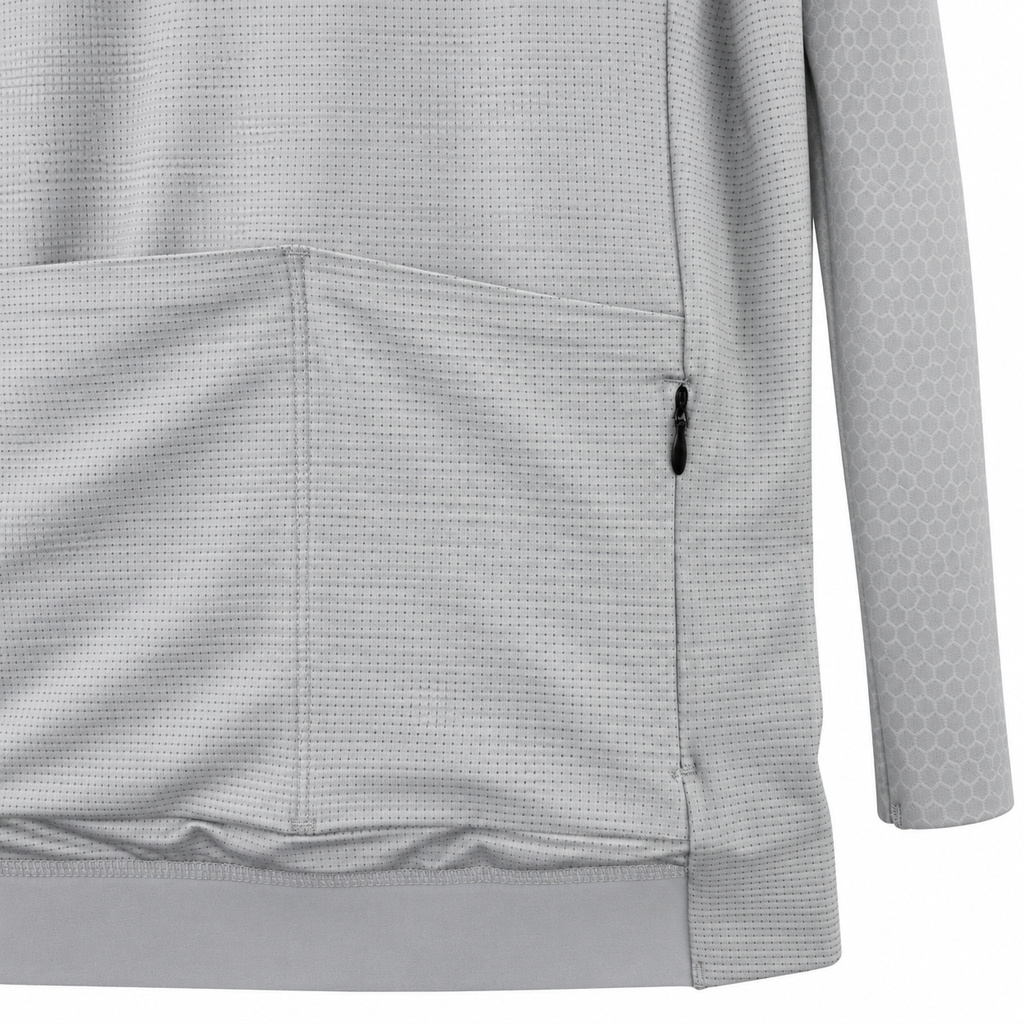 Close-up of a light gray long-sleeve athletic top with a textured micro-dot pattern, a side zip pocket, and a subtle honeycomb pattern on the sleeve.