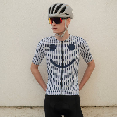 Person wearing a cycling outfit with a smiley face design on a striped background
