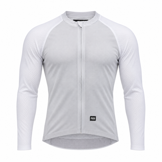 A white long-sleeve cycling jersey with a full-length front zipper, raglan sleeves, and a small black PUMA logo patch near the lower hem, shown on a clean white background.