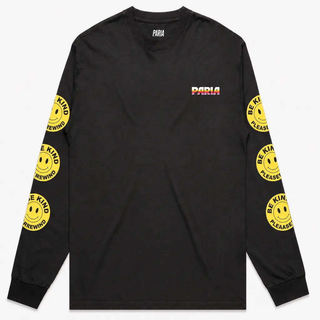 Black long-sleeve t-shirt with PARIA printed on the front left breast in a white, orange, and pink gradient. The sleeves feature yellow smiley face graphics with the text 'BE KIND REWIND'.