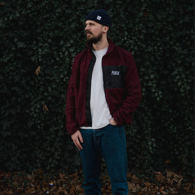 A purple fleece cycling jacket with zip pockets and contrast zips, featuring a collar and the brand name 'Paria' on the chest.