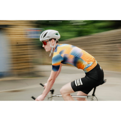 A short sleeve cycling jersey with a geometric heatmap design in shades of orange, blue, and black.