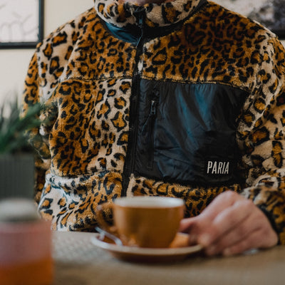 A leopard print sherpa fleece cycling commuter jacket with zipper pockets and contrasting zippers.