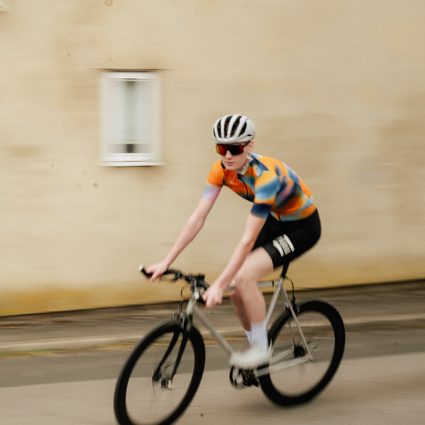 A short sleeve cycling jersey with a geometric heatmap design in shades of orange, blue, and black.