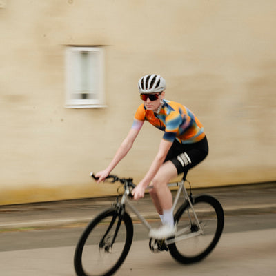 A short sleeve cycling jersey with a geometric heatmap design in shades of orange, blue, and black.