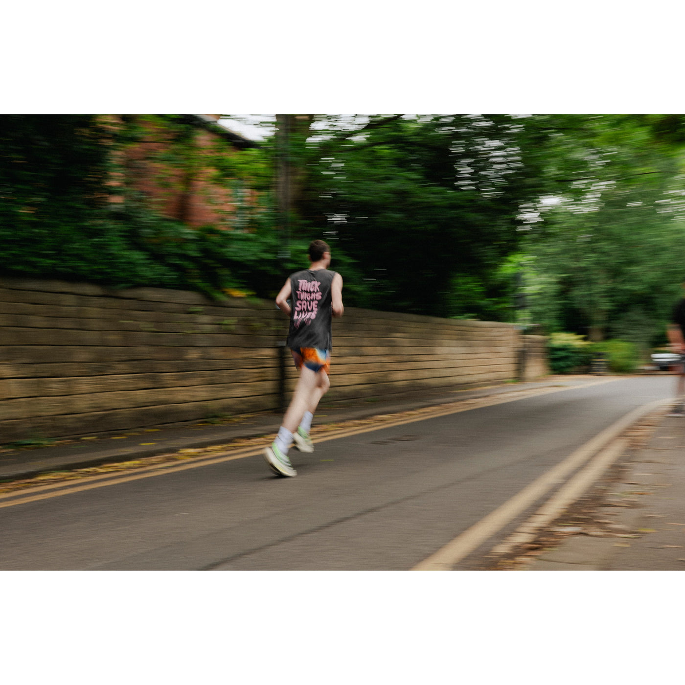 Person running on a road in stonewash black sleeveless vest 